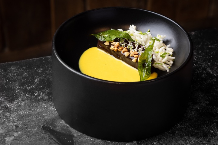 Berenjena negra asada con tamarindo, arroz jamín crujiente, curry de coco, cúrcuma, jengibre, fenogreco y lima kaffir